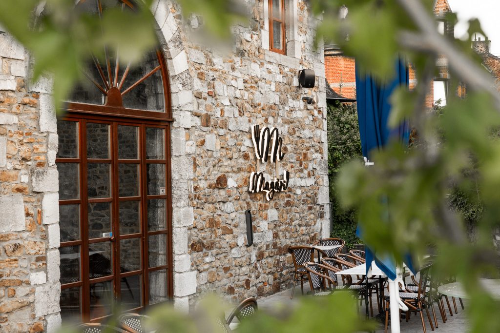 La façade en pierre de Magari et ses parasols bleus